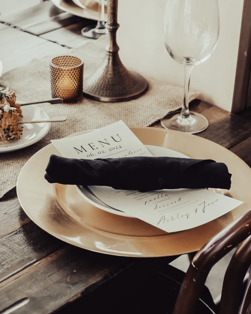 A table set with a folded menu and candlelight