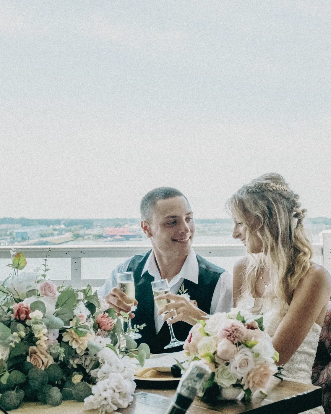 A bride and groom toasting at a rooftop wedding
